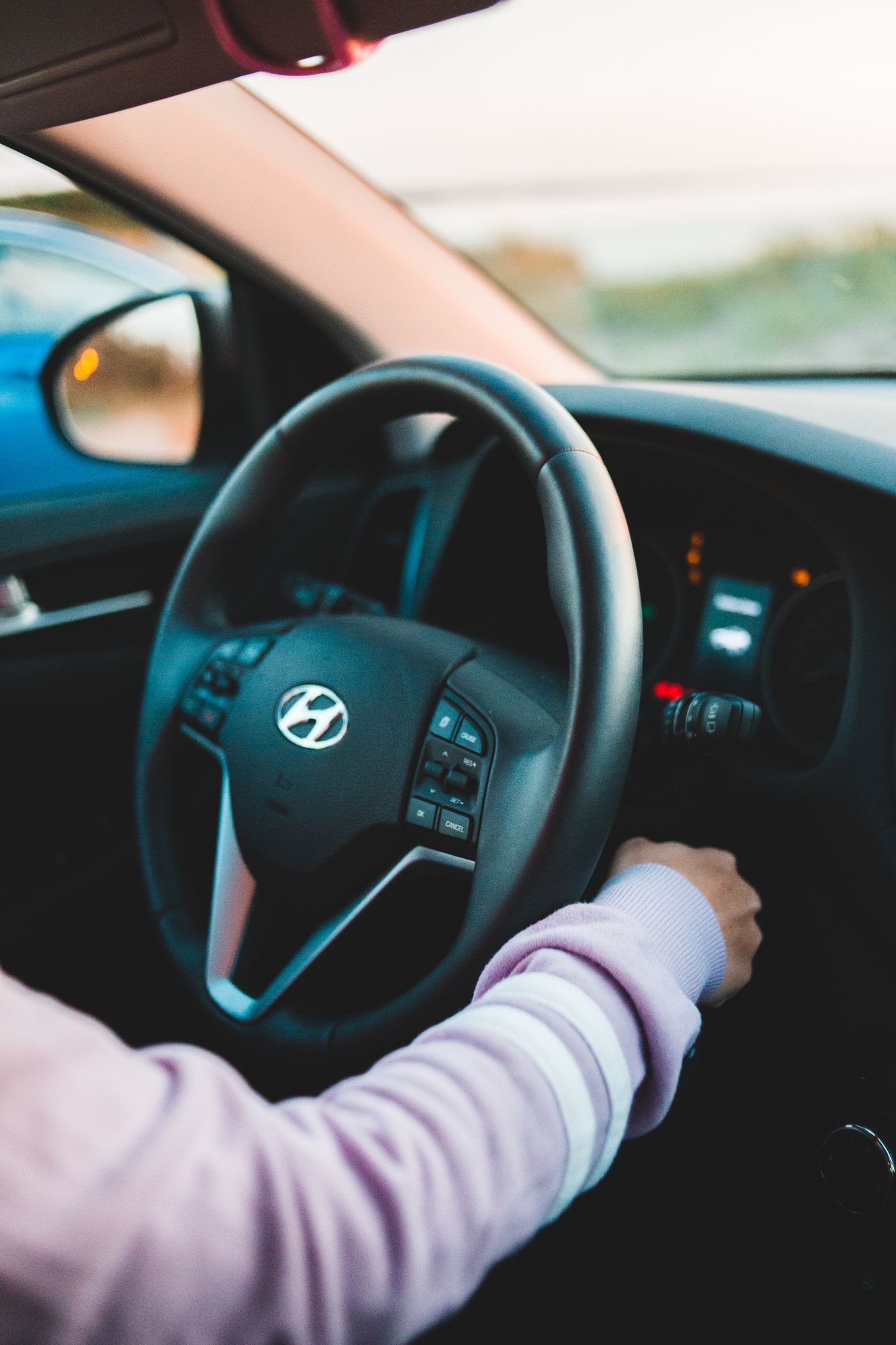 Handen aan het stuur tijdens een rijles, close-up